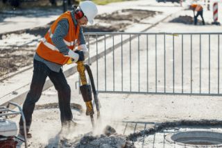 Un trabajador en una obra en construcción usa un martillo neumático